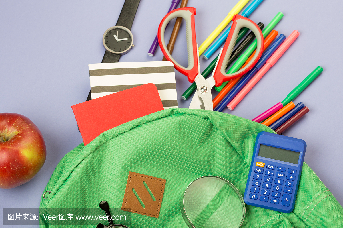 书包和学习用品:放大镜,记事本,毡尖笔,眼镜,剪刀,计算器,手表在蓝色的纸背景